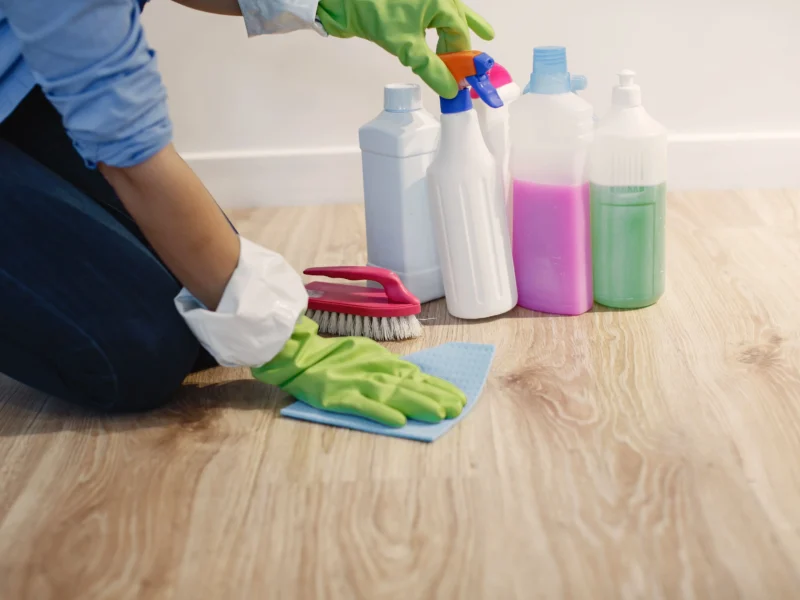 Person using a microfiber mop on light-toned luxury vinyl plank flooring in a Sarasota home